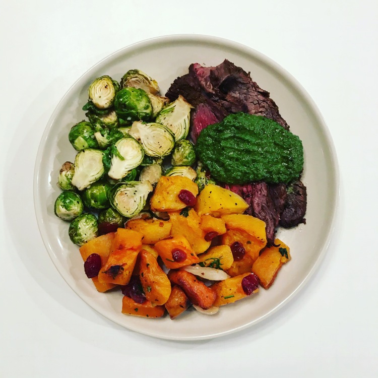 carne asada with pesto brussels sprouts and butternut squash on a plate