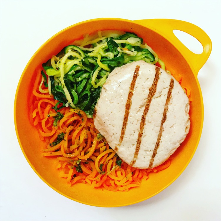 zucchini noodles spiralized carrot with coconut oil and chopped basil and a trader joe's roasted chicken patty