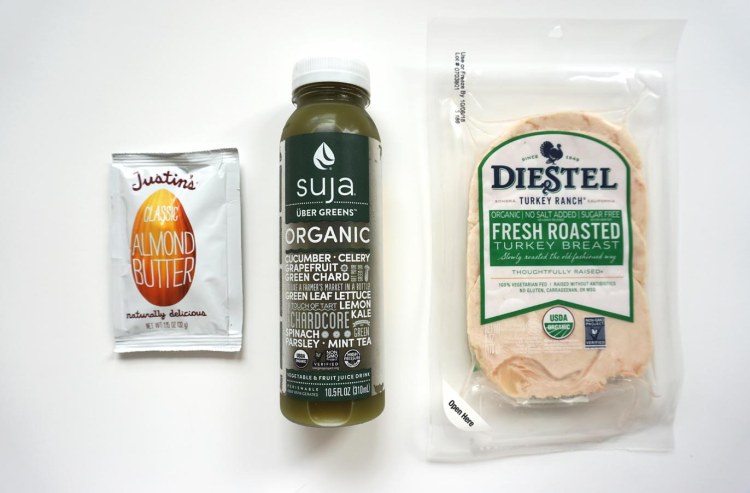justins almond butter packet beside bottle of suja uber greens juice beside a packet of diestel turkey